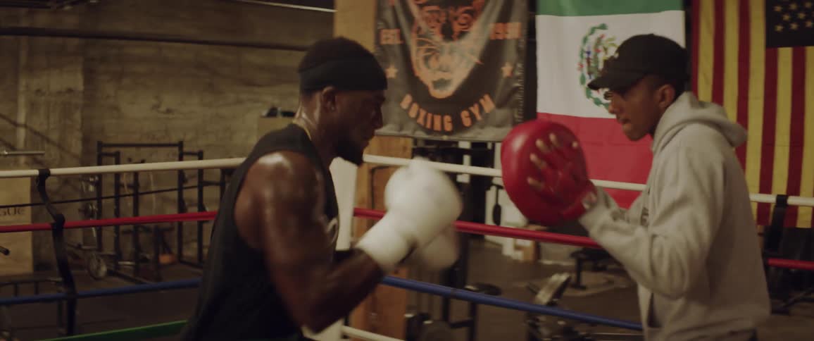 Two boxers are sparring in the ring
