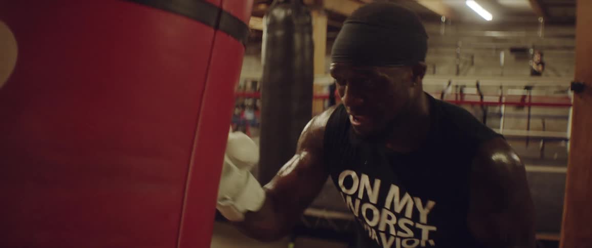 A man is exercising punching a heavy bag