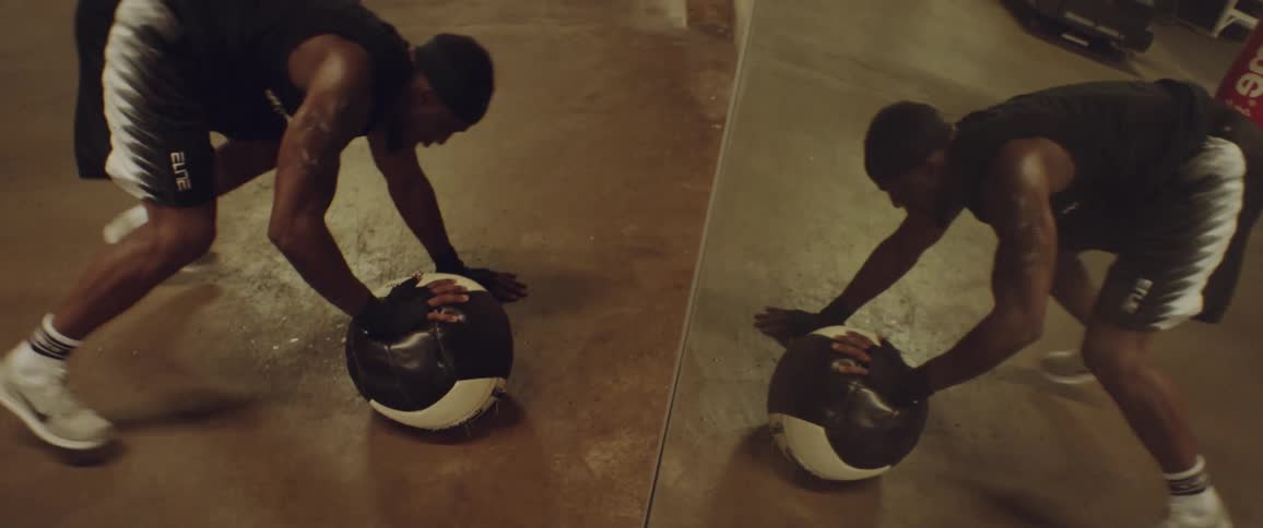 A man exercises with a heavy ball