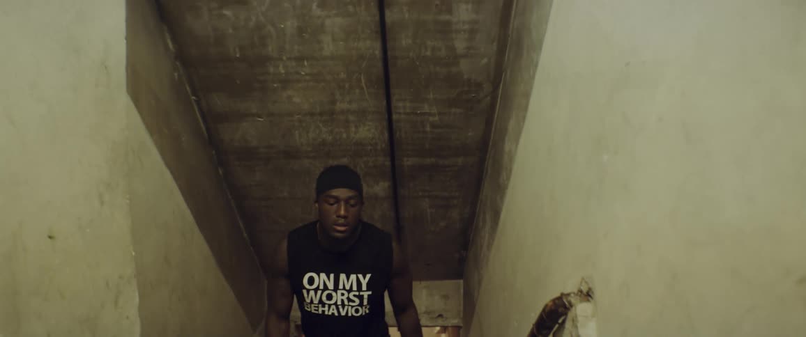 A man ascends a staircase holding boxing gloves