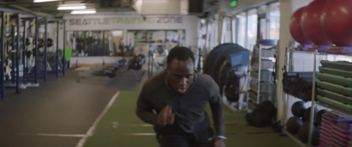 Man sprinting side to side and backwards in a gym