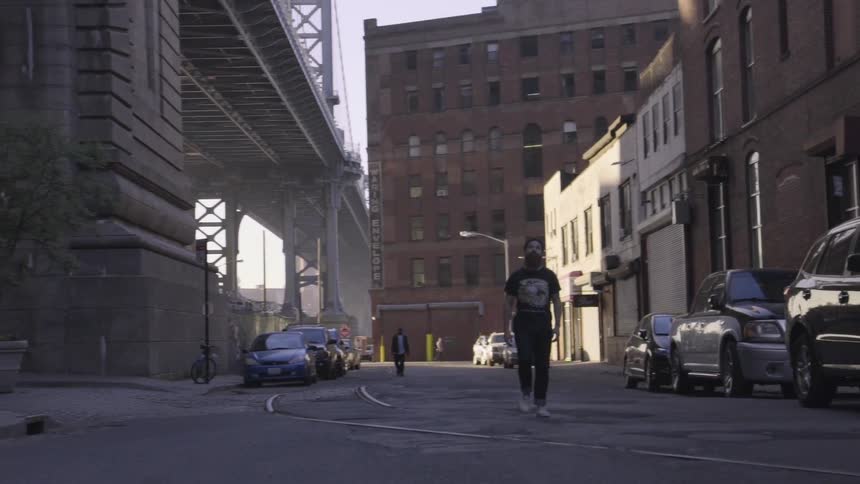 A person with a beard walks down a road