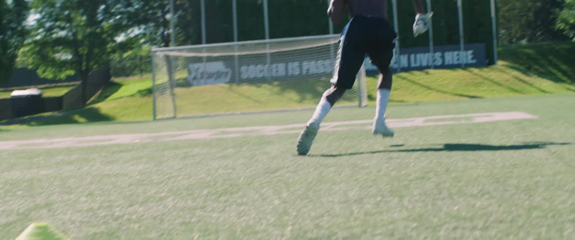 Man sprints on a grassy field