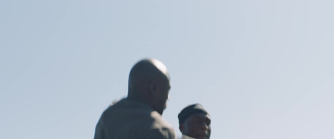 Two men jump into the air to catch a football