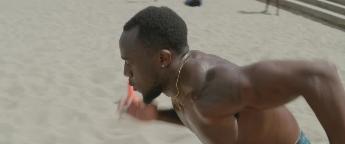 Man sprints backwards and side to side on a sandy beach