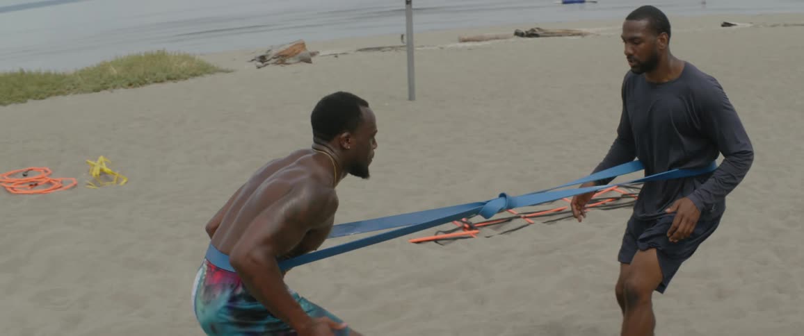 Men exercise on a sandy beach