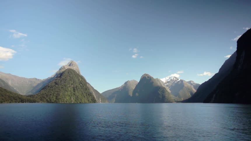 A lake leads to a mountain range on a clear day