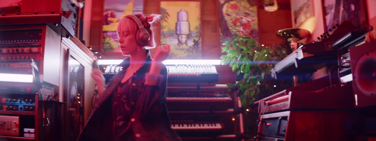 A woman is dancing by music equipment