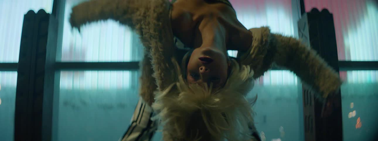 A teenage girl dancing in front of bright lights