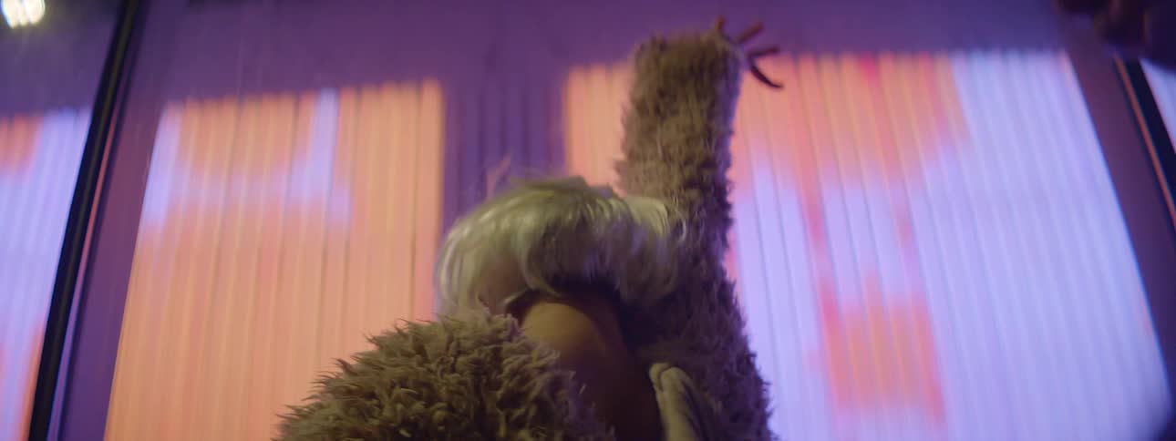 A woman is dancing by a billboard