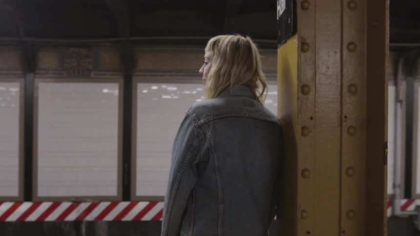 A woman is waiting for a train in the subway