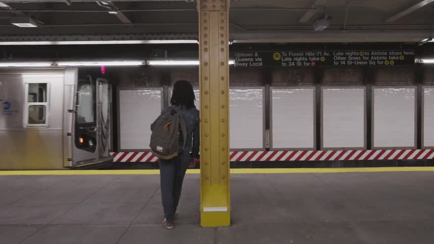 A person stands by while a subway train passes by