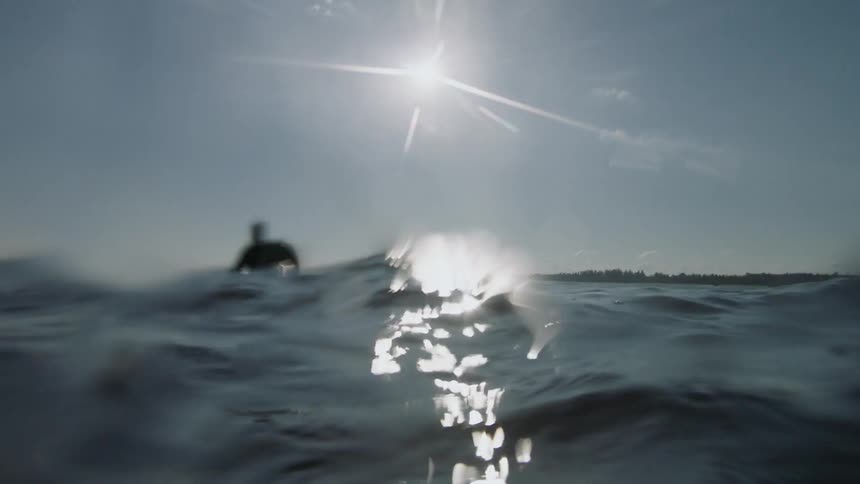 A man floats in the water on a sunny day