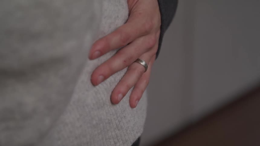 A ringed hand wrapped around another person