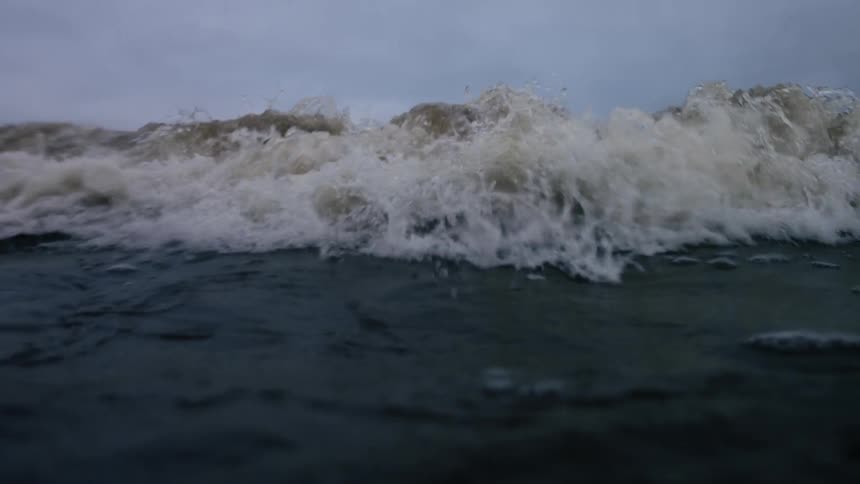 Close up at sea level of a wave crashing