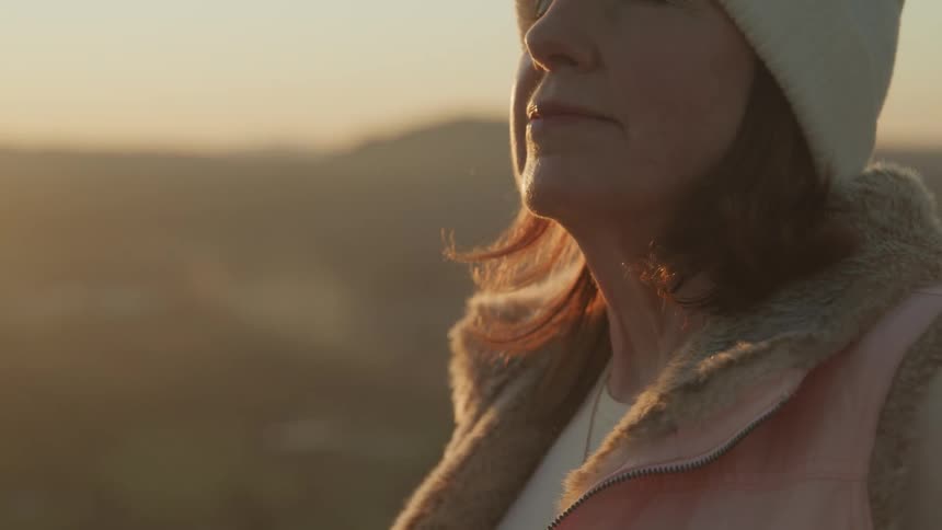 A woman is smiling with her eyes closed