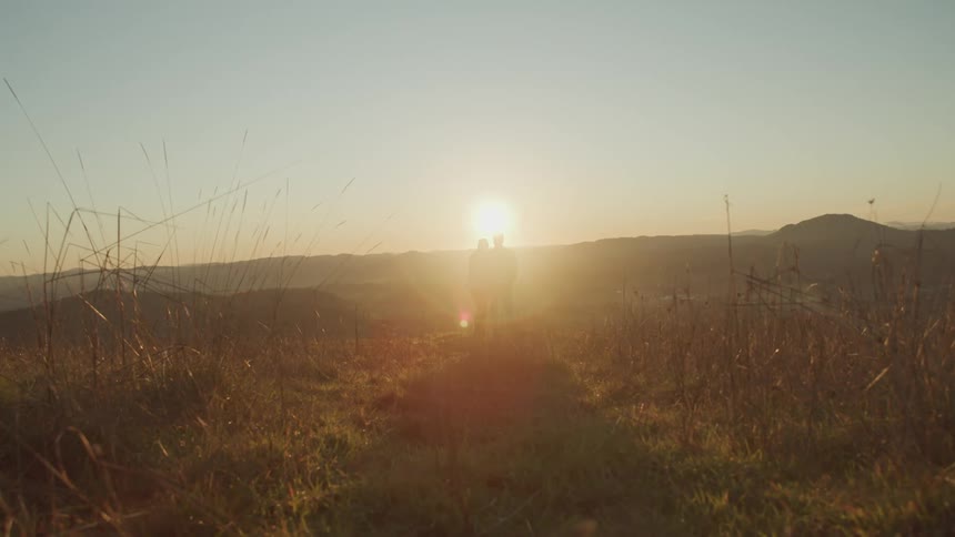 Two people standing in the grasslands