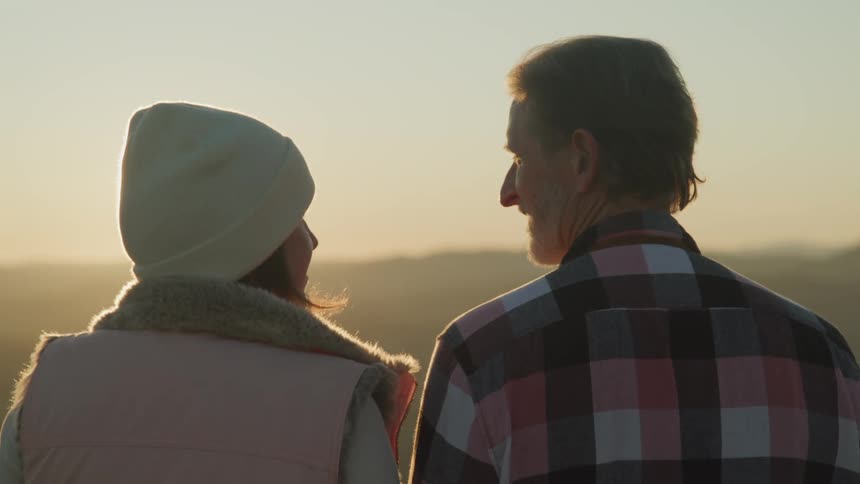 A man and woman watching the sun set