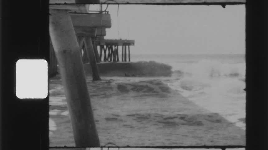 Waves crash against the shore near the pier