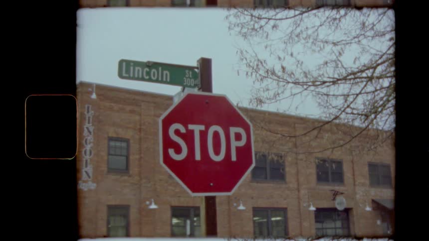 A stop sign near a brick building in a town
