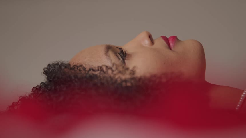 A woman is laying down while wearing makeup