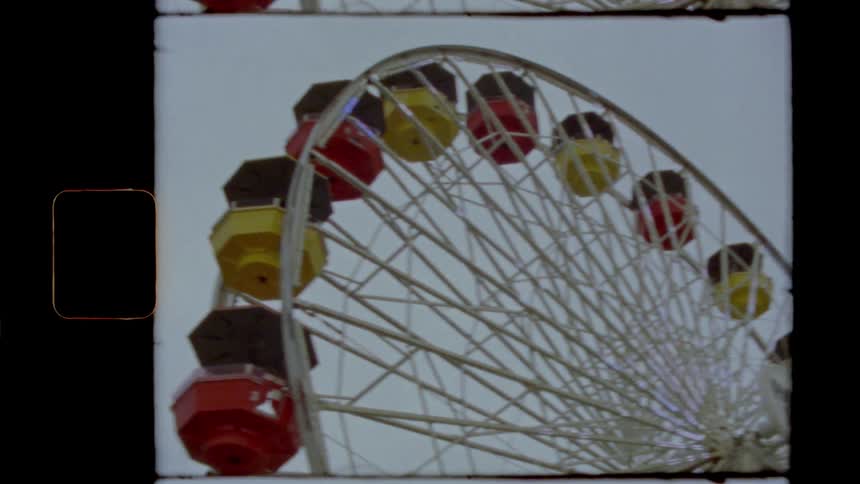 Lights twinkling on a ferris wheel under a cloudy evening sky