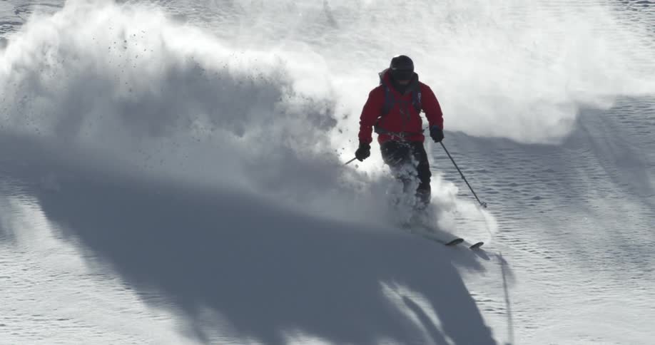 A skier turns down a snowy slope