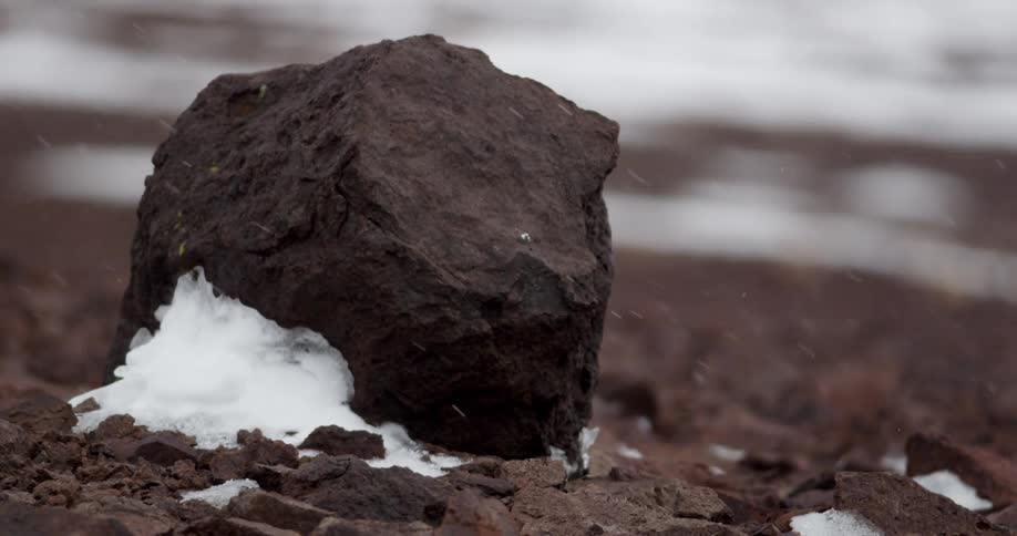 Snow falls on a desert rock