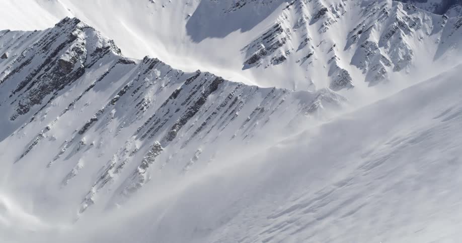 A snowy mountain with windblown slopes