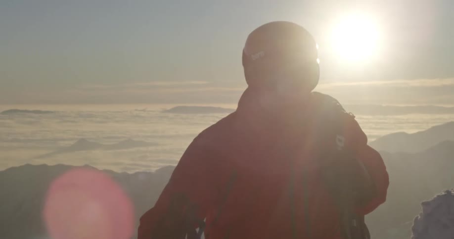 A climber moves up a mountain in the sunset