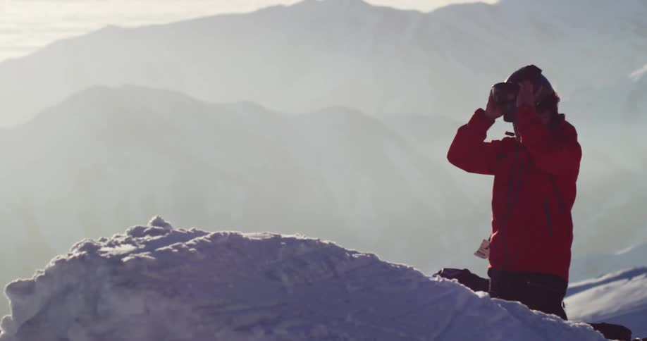 A skier puts on his helmet