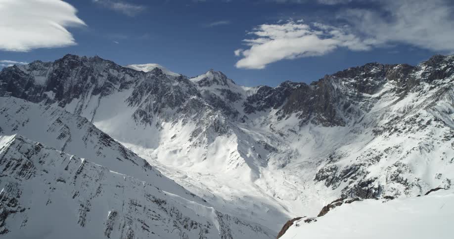 Snow covered mountains sit under the blue sky