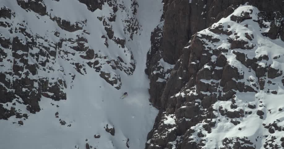Skier navigates a steep couloir
