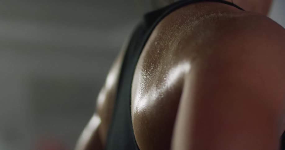 Close up of a womans back covered in sweat from exercising