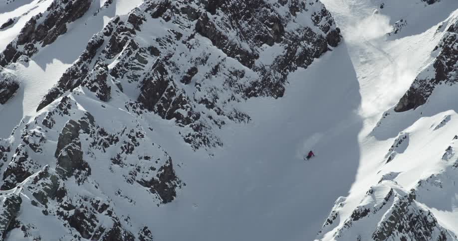 A skier quickly descends a rocky mountain
