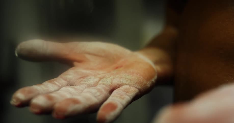 Person stands with white powder hands held palm up