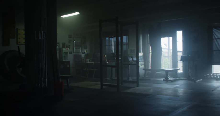 A dark garage and basement is used as a personal gym and storage