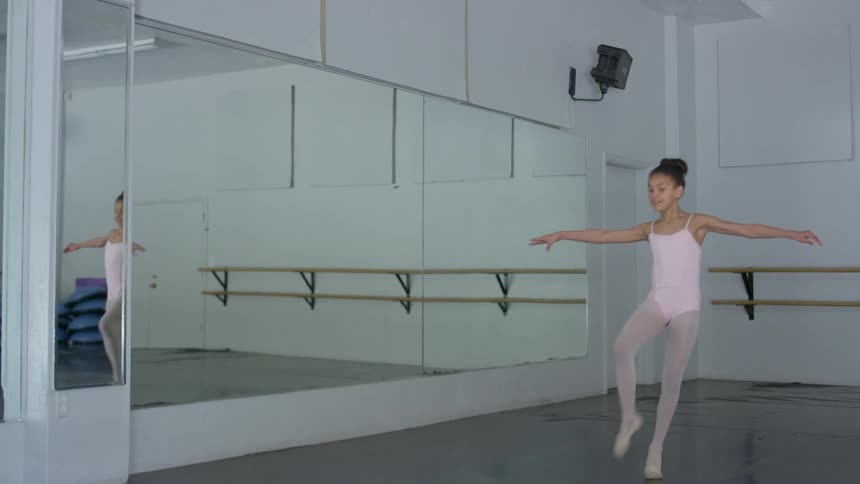 A female child practicing ballet dance in a dance studio