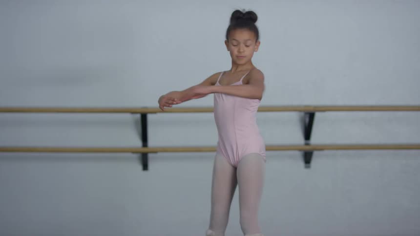 A ballerina girl dancing ballet in a dance studio