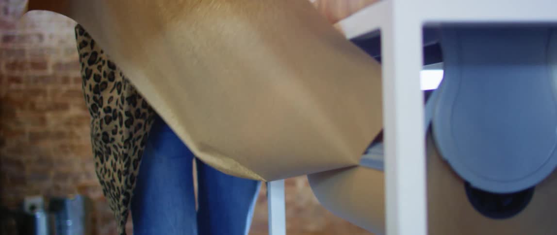 A woman tears a piece of fabric from a roll to work