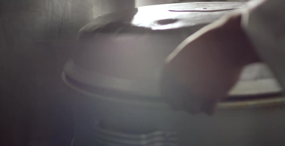 A large pot of pasta and sauce that a person lifts up the lid