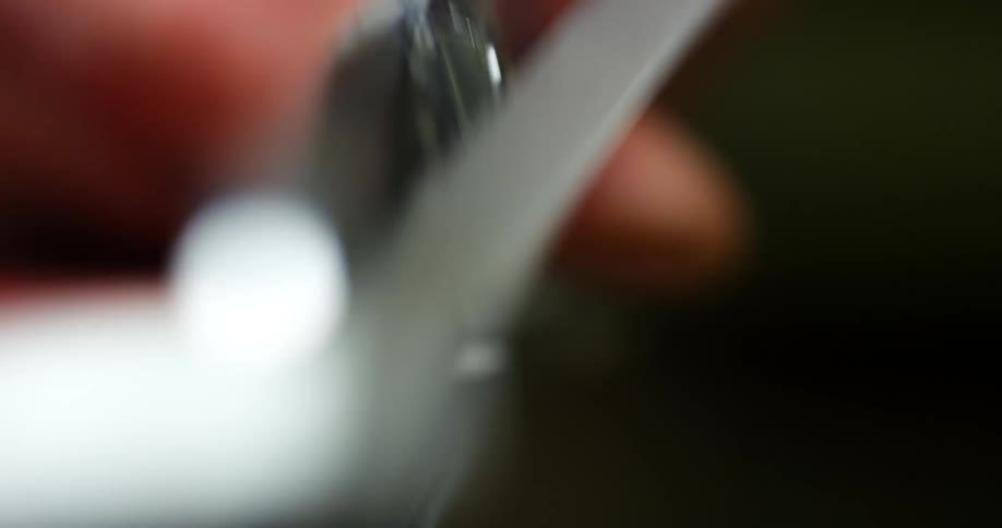 A person cuts a strip off an item