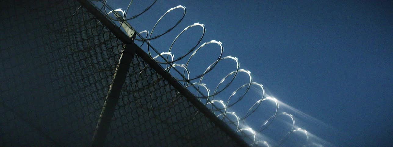 Sunlight shining on a barbed wire fence