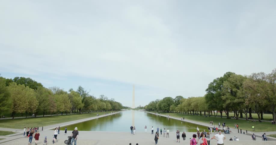 Tourists walking about the lincoln memorial reflecting pool during the day