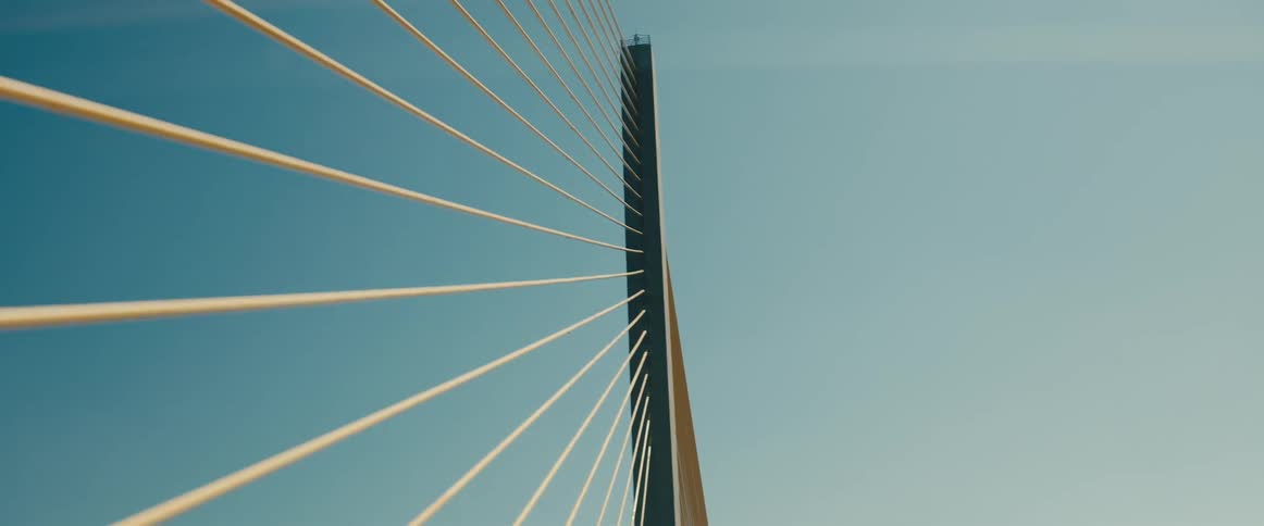 Structure and attached cables run parallel to each other against a clear blue sky