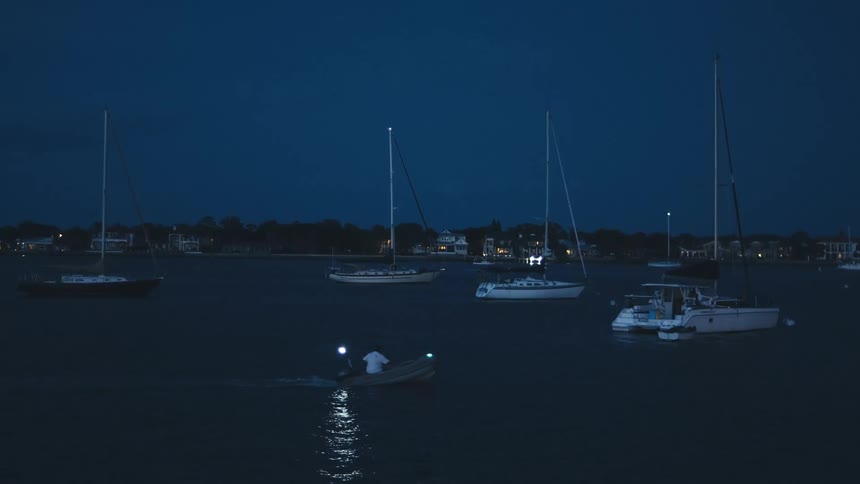 Person on small boat in marina at night