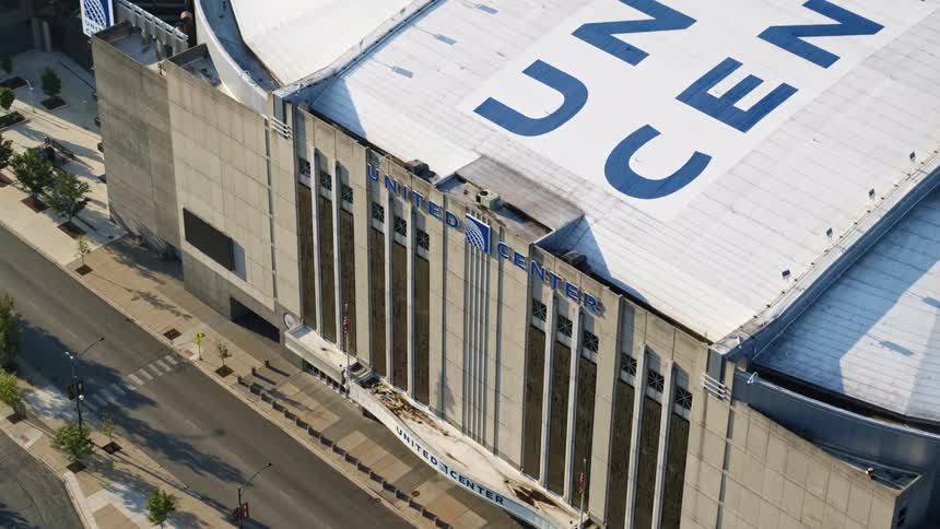 A bicyclist rides down an empty street in front of Chicago United Center