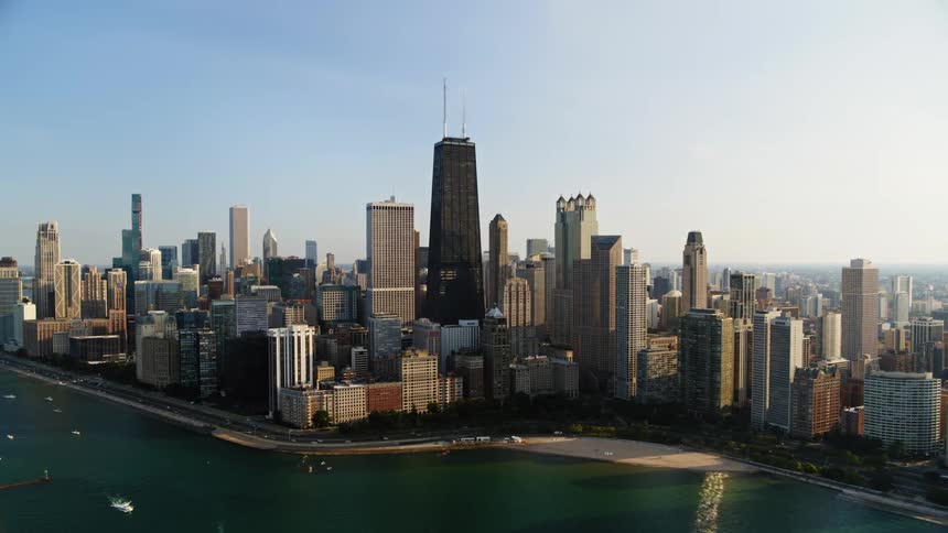 Boats sail through the lake in front of the Chicago skyline