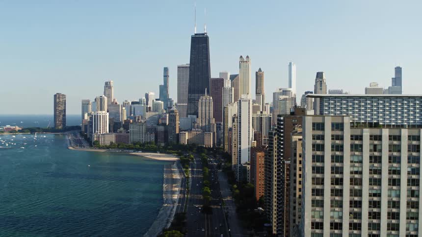 An aerial view of skyscrapers next to a bay in a large city