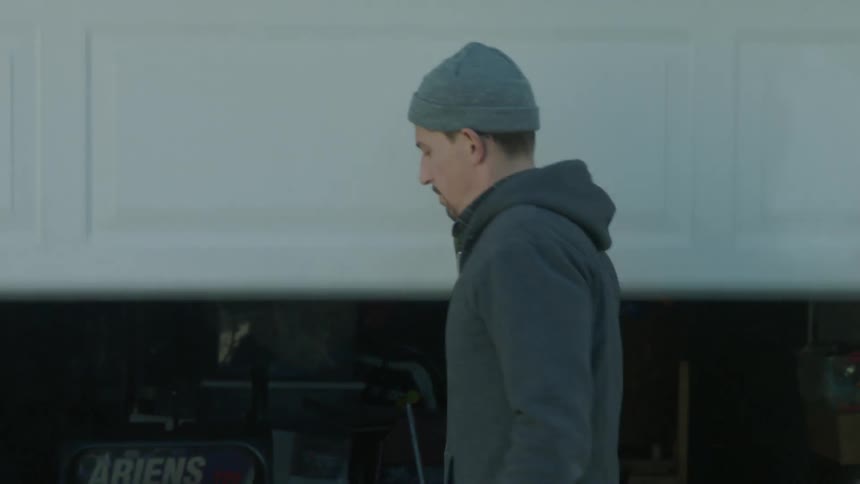 A man pulls his garage closed